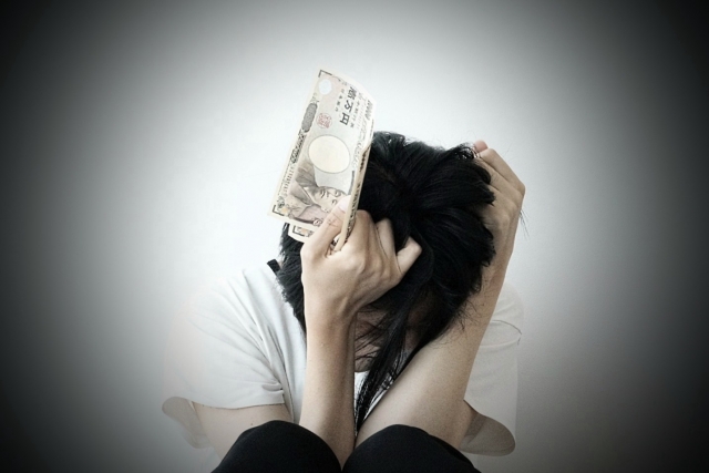 お金を手に頭を抱える。調布市で債務整理の無料相談が司法書士に可能